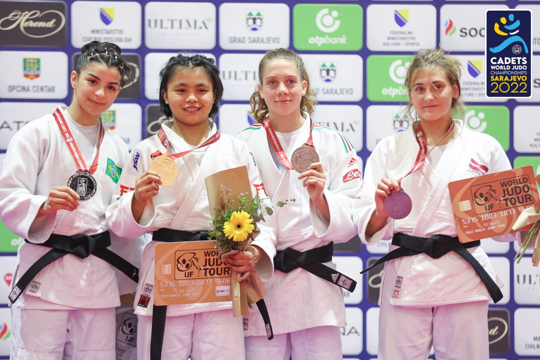 Linthoi Chanambam (gold) on the podium with the silver and bronze medallists at the 2022 World Cadet Judo Championships in Sarajevo